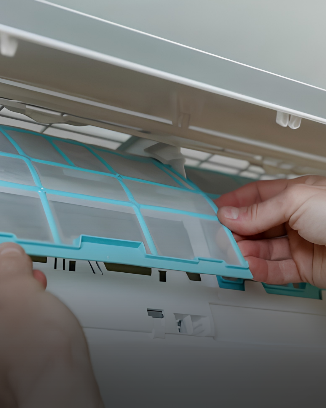 Hand verwijdert het luchtfilter van een airco tijdens controle en onderhoud