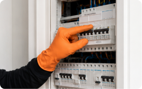 Elektricien controleert installatieautomaten en capaciteit in een groepenkast